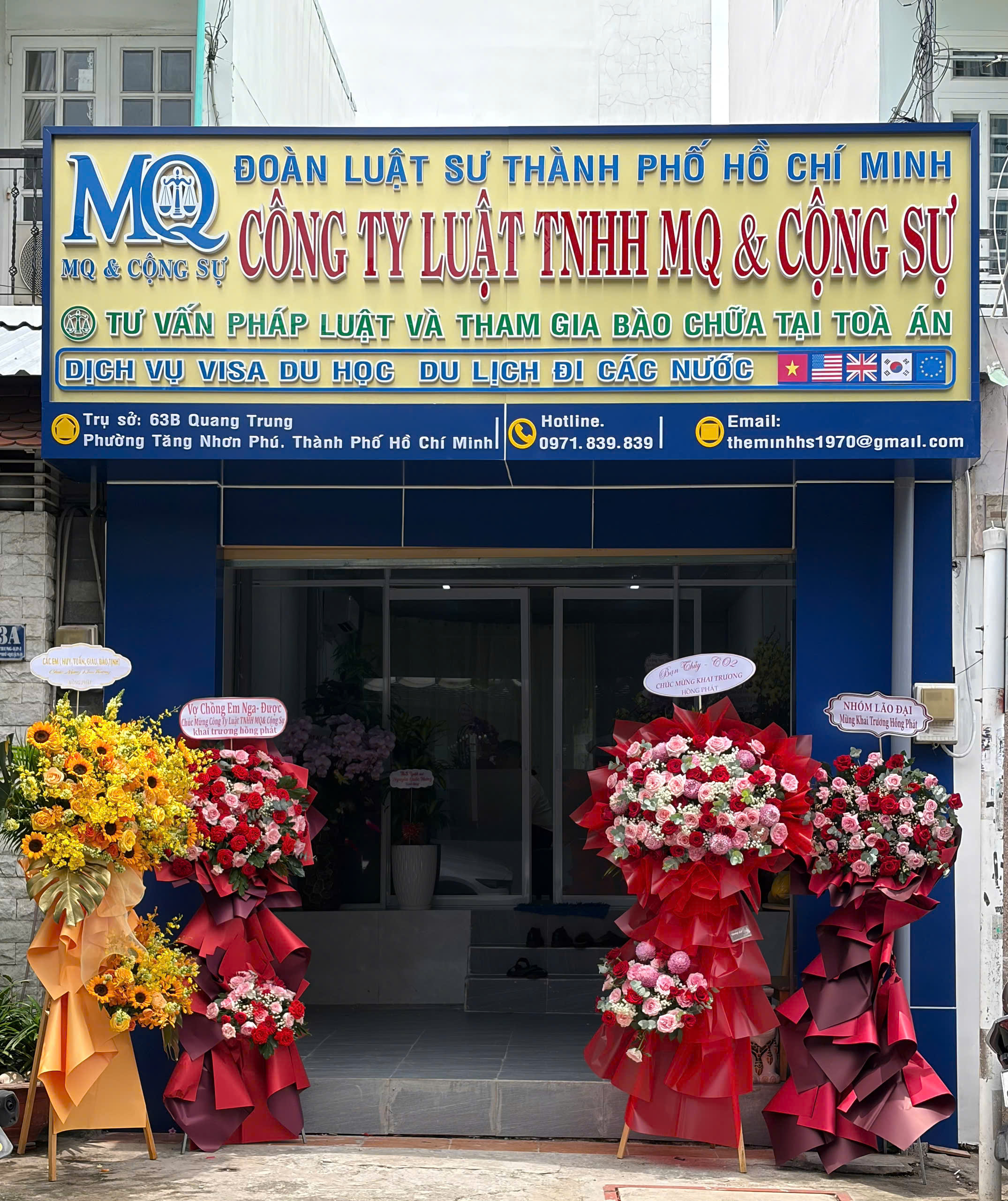 Mặt tiền Công ty luật MQ và Cộng sự tại 63B Quang Trung với bảng hiệu và hoa khai trương